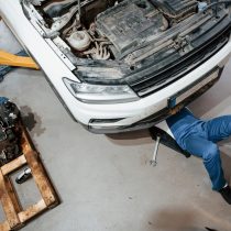 Artificial lighting. Employee in the blue colored uniform works in the automobile salon.